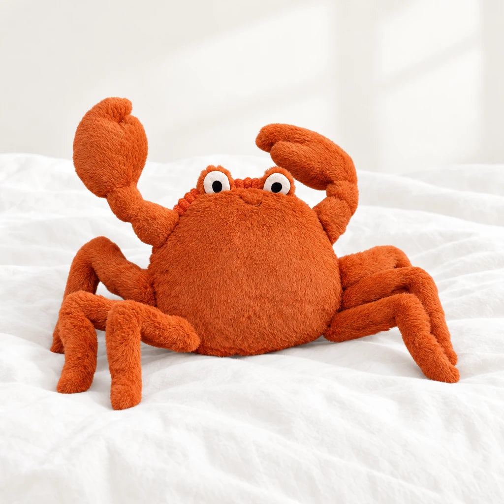 Peluche crabe tout doux posée sur un lit blanc, en pleine lumière