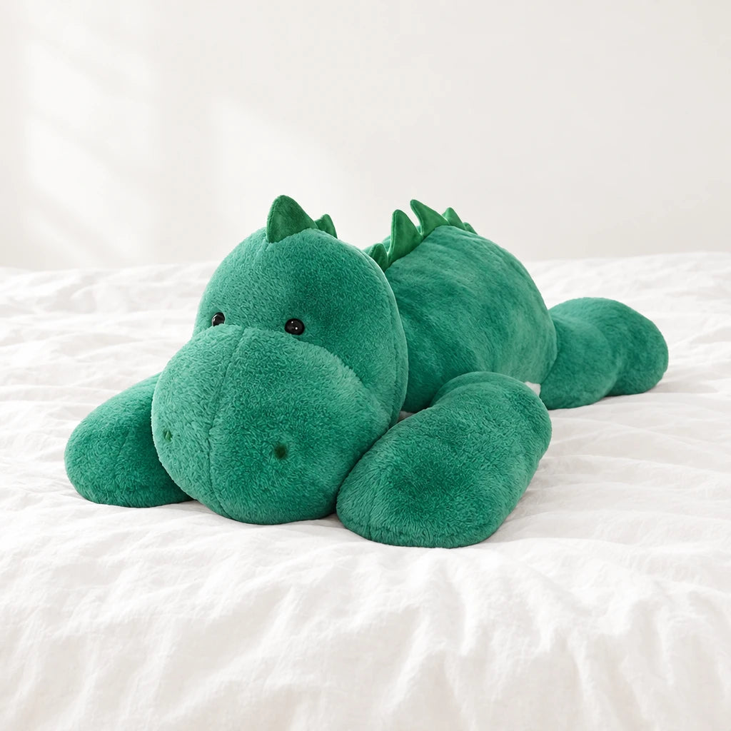 Peluche dinosaure géant relax posée sur un lit blanc, en pleine lumière