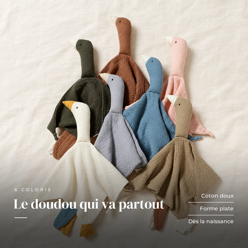 Peluche doudou oie pour bébé en coton présentée à plat sur du lin crème. Le doudou qui va partout : coton doux, forme plate, dès la naissance