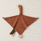 Peluche doudou oie pour bébé en coton marron présentée à plat sur du lin crème