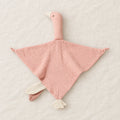 Peluche doudou oie pour bébé en coton rose présentée à plat sur du lin crème