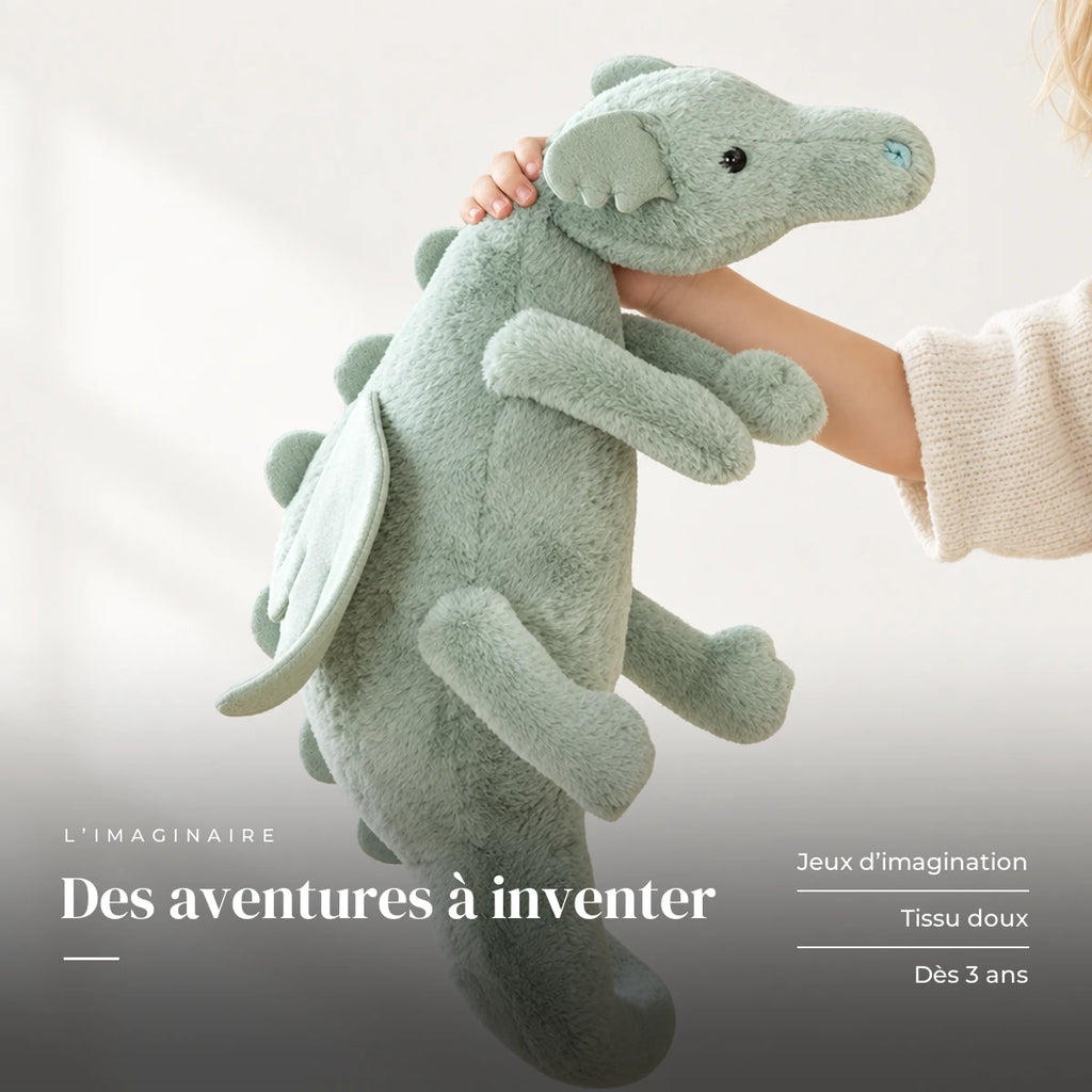 Dragon en peluche aux couleurs pastel avec un enfant dans une chambre lumineuse. Des aventures à inventer : jeux d’imagination, tissu doux, dès 3 ans