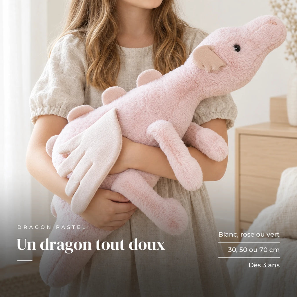 Dragon en peluche aux couleurs pastel avec un enfant dans une chambre lumineuse. Un dragon tout doux : blanc, rose ou vert, 30, 50 ou 70 cm, dès 3 ans