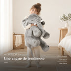 Peluche éléphant oreiller grise avec un enfant dans une chambre lumineuse. Une vague de tendresse : ultra-douce, gris doux, dès 3 ans