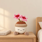 Peluche kawaii fleurs en pot de terre modèle marguerites roses posée sur une table de chevet en bois clair