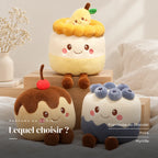 Peluche kawaii gâteau gourmand posée sur un lit en lin blanc. Lequel choisir ? : framboise ou chocolat, poire, myrtille
