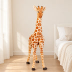 Peluche géante girafe posée sur un lit en lin blanc