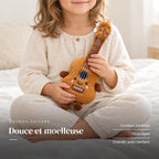 Peluche instrument kawaii guitare souriante tenue par un enfant pour montrer sa taille réelle. Douce et moelleuse : couleur caramel, tous âges, grandit avec l’enfant