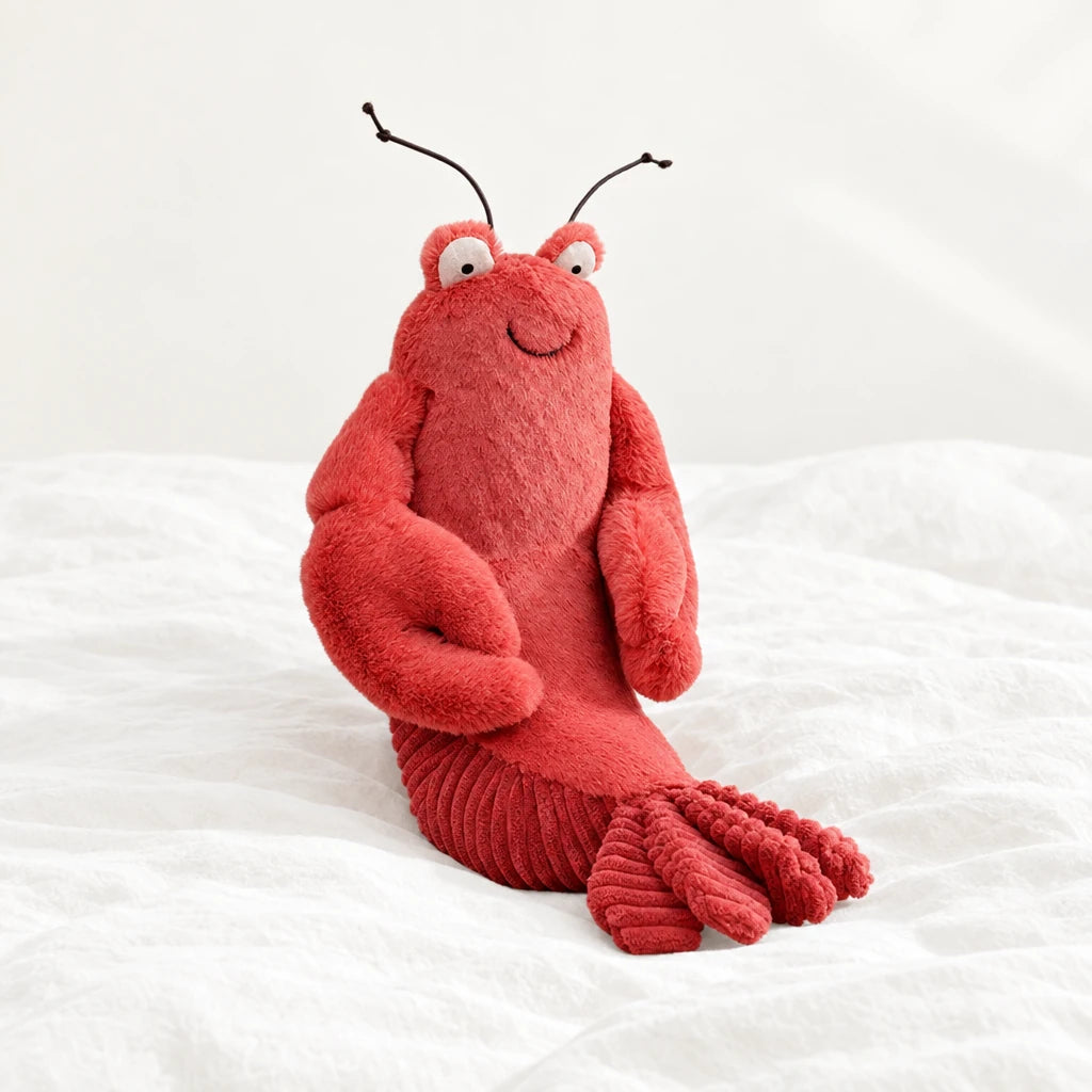 Peluche homard tout doux posée sur un lit blanc, en pleine lumière
