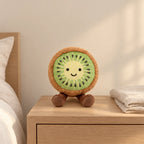 Peluche fruit kawaii kiwi joyeux posée sur une table de chevet en bois clair