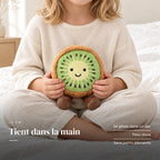 Peluche fruit kawaii kiwi joyeux tenue par un enfant pour montrer sa taille réelle. Tient dans la main : se glisse dans un sac, tissu doux, sans petits éléments