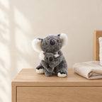 Peluche koala avec son bébé grise avec bébé posée sur une table de chevet en bois clair