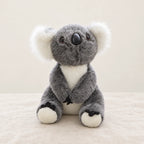 Peluche koala avec son bébé grise sur fond crème, en studio