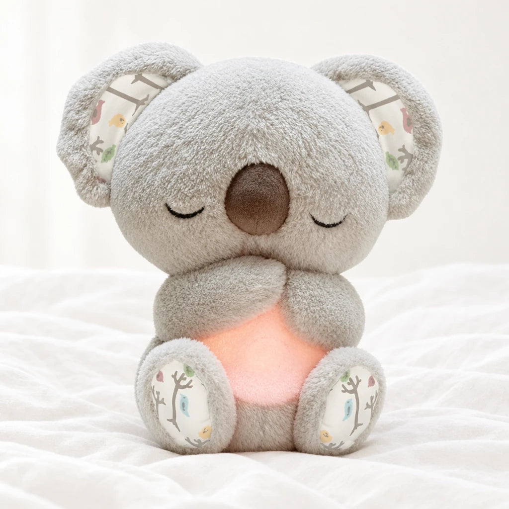 Peluche koala qui respire posée sur un lit blanc, en pleine lumière
