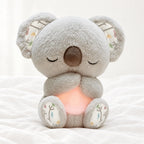 Peluche koala qui respire posée sur un lit blanc, en pleine lumière