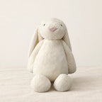Lapin en peluche moelleux pour bébé blanc sur fond crème, en studio
