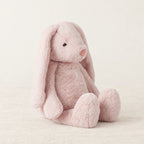 Lapin en peluche moelleux pour bébé rose sur fond crème, en studio