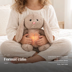 Peluche lapin qui respire tenue par un enfant pour montrer sa taille réelle. Format câlin : 2 boutons dans les pieds, respiration lente, gris, nez rose