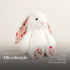 Lapin en peluche avec motif fleuri blanc sur fond crème, en studio. Elle a du style : 31 cm, tissu doux, blanc, rose, gris, beige