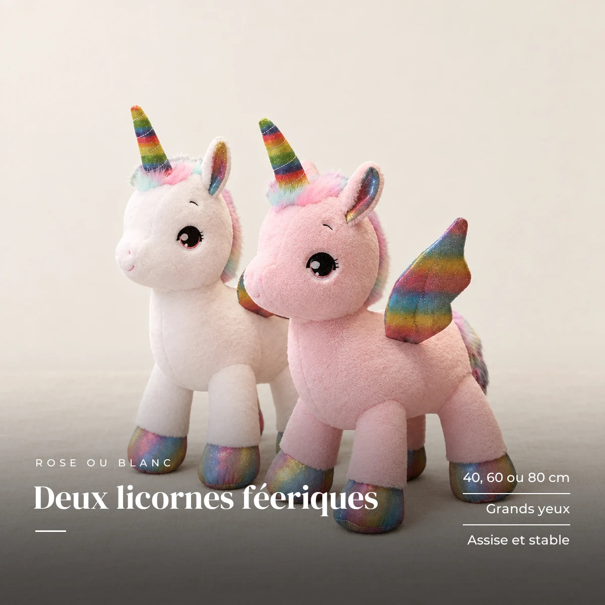 Peluche licorne féerique avec corne et ailes colorées sur fond crème, en studio. Deux licornes féeriques : 40, 60 ou 80 cm, grands yeux, assise et stable