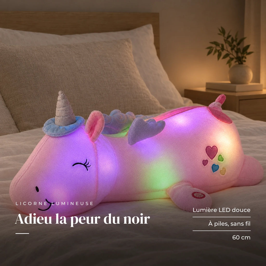 Peluche licorne rose veilleuse lumineuse et magique posée sur un lit en lin blanc. Adieu la peur du noir : lumière LED douce, à piles, sans fil, 60 cm