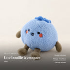 Peluche fruit kawaii myrtille attendrissante sur fond crème, en studio. Une bouille à croquer : joues colorées, pelage moelleux, détails brodés