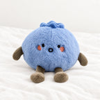 Peluche fruit kawaii myrtille attendrissante posée sur un lit blanc, en pleine lumière