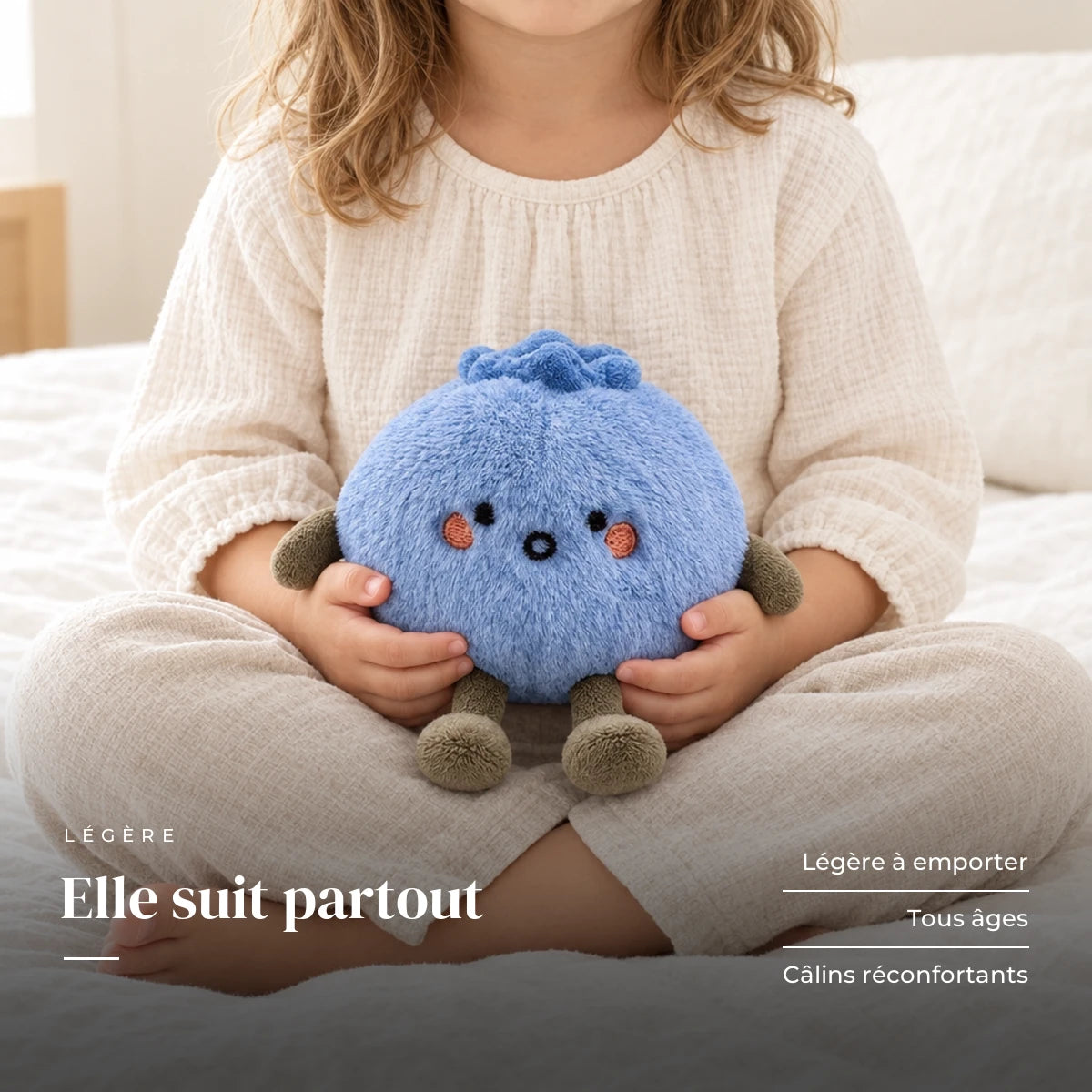 Peluche fruit kawaii myrtille attendrissante tenue par un enfant pour montrer sa taille réelle. Elle suit partout : légère à emporter, tous âges, câlins réconfortants