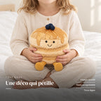Peluche petit dej’ pancakes kawaii tenue par un enfant pour montrer sa taille réelle. Une déco qui pétille : visage brodé, texture agréable, tous âges