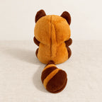 Peluche panda roux qui respire vue de dos sur fond crème
