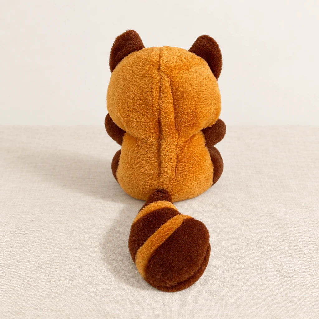 Peluche panda roux qui respire vue de dos sur fond crème
