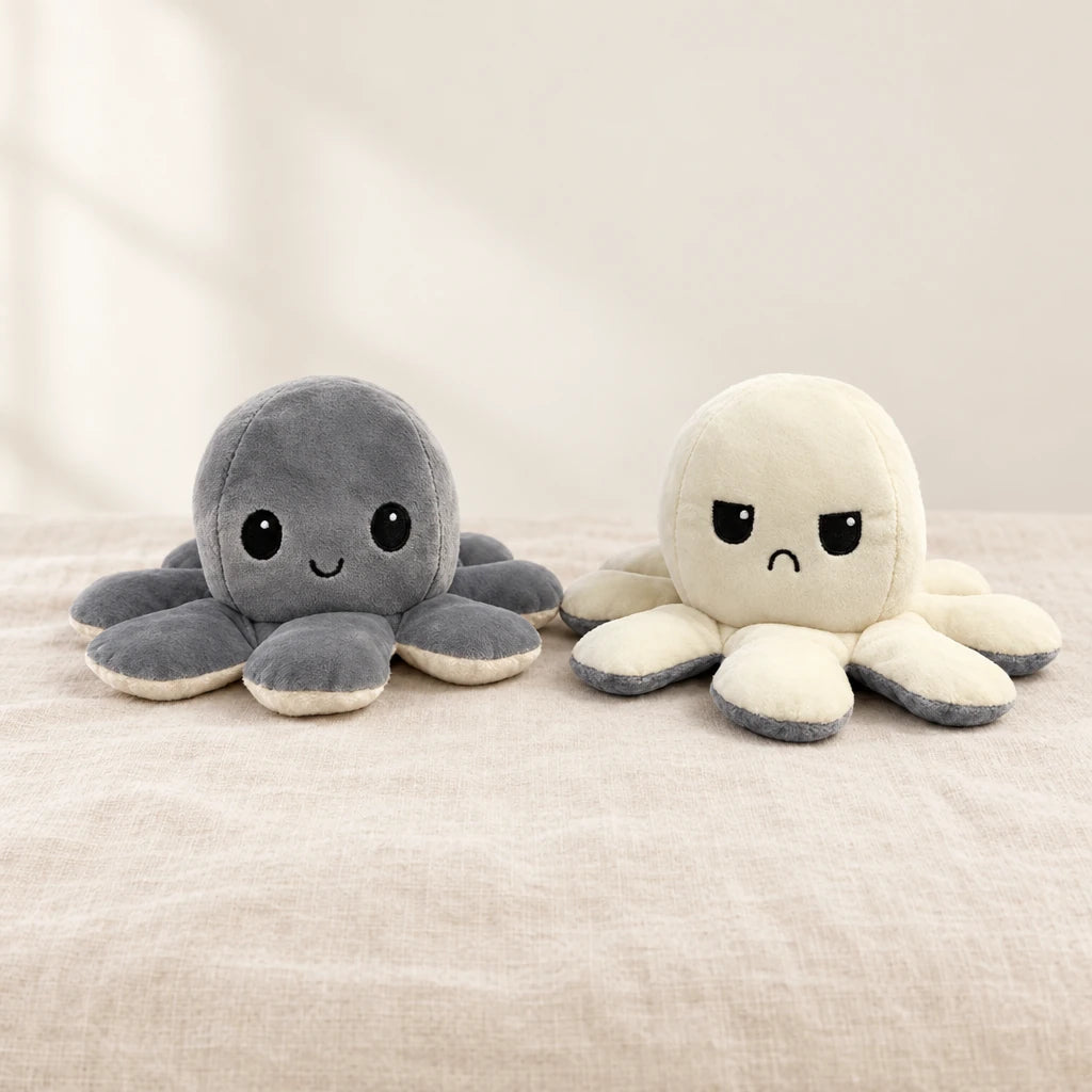 Peluche pieuvre réversible grise sur fond crème, en studio