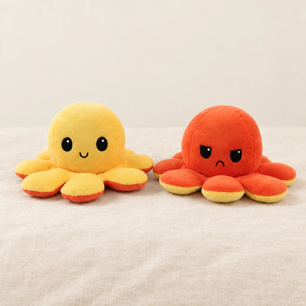 Peluche pieuvre réversible jaune sur fond crème, en studio