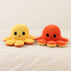 Peluche pieuvre réversible jaune sur fond crème, en studio