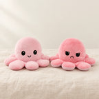Peluche pieuvre réversible rose sur fond crème, en studio