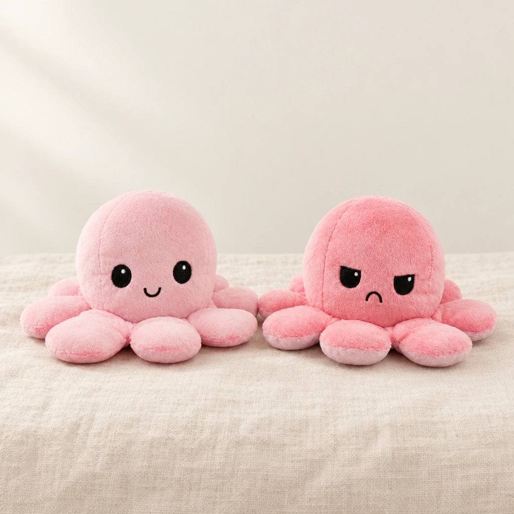 Peluche pieuvre réversible rose sur fond crème, en studio