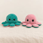 Peluche pieuvre réversible verte sur fond crème, en studio