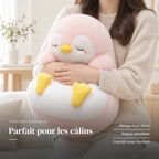 Peluche pingouin moelleux endormi dans les bras d’un adulte. Parfait pour les câlins : pelage tout doux, peaux sensibles, grandit avec l’enfant