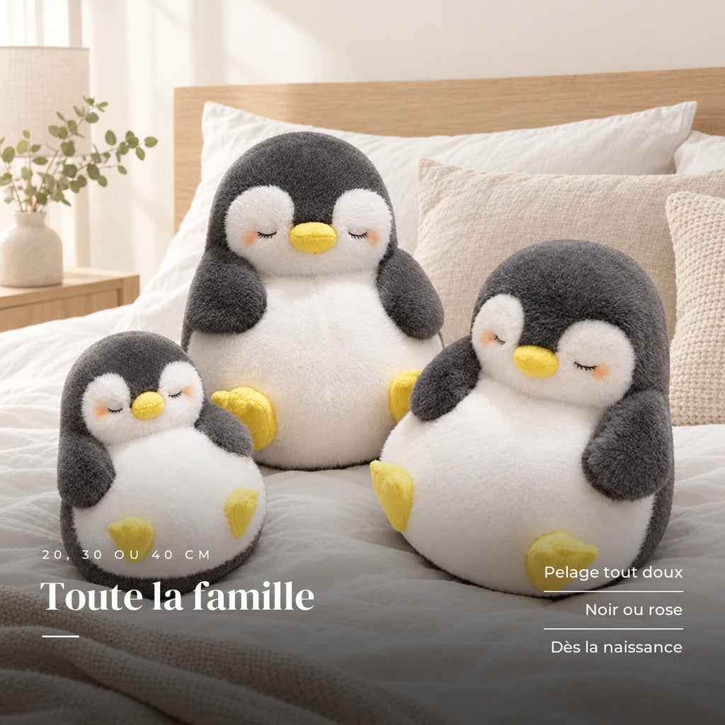 Peluche pingouin moelleux endormi posée sur un lit en lin blanc. Toute la famille : pelage tout doux, noir ou rose, dès la naissance