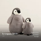 Peluche pingouin manchot câlin gris sur fond crème, en studio. Le copain fidèle : pelage duveteux, ventre moelleux, tous âges