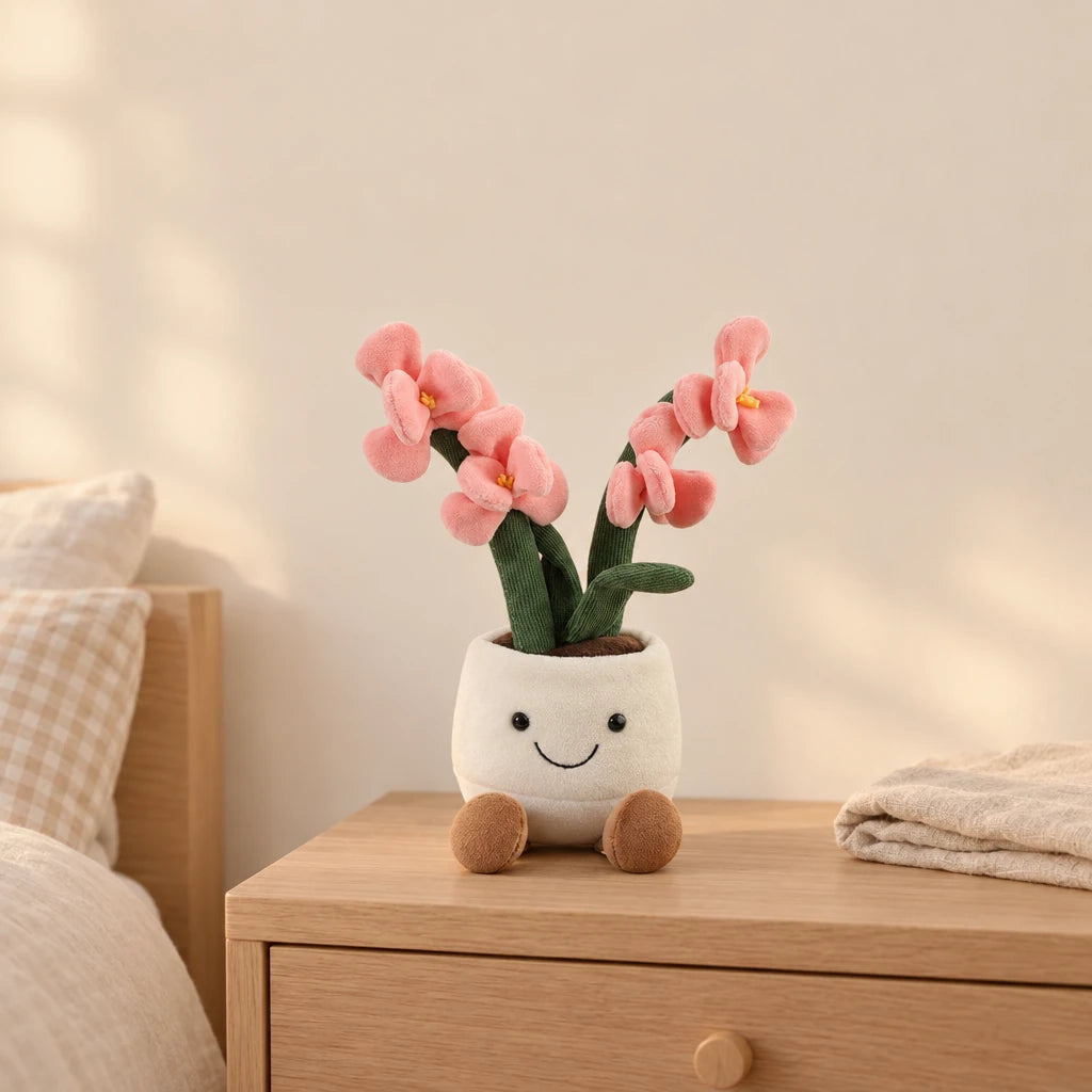 Peluche plante kawaii orchidée douce et colorée rose posée sur une table de chevet en bois clair