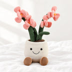Peluche plante kawaii orchidée douce et colorée posée sur un lit blanc, en pleine lumière