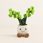 Peluche plante kawaii orchidée douce et colorée verte sur fond crème, en studio