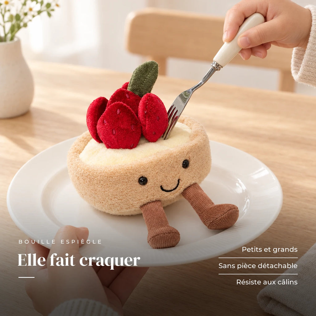 Peluche tarte fraise gourmande kawaii dans une assiette sur une table en bois. Elle fait craquer : petits et grands, sans pièce détachable, résiste aux câlins