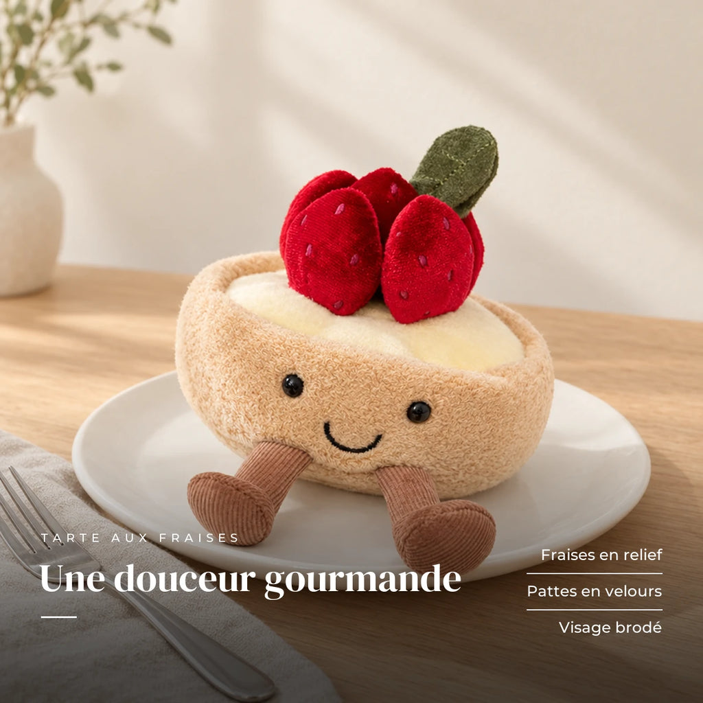 Peluche tarte fraise gourmande kawaii dans une assiette sur une table en bois. Une douceur gourmande : fraises en relief, pattes en velours, visage brodé
