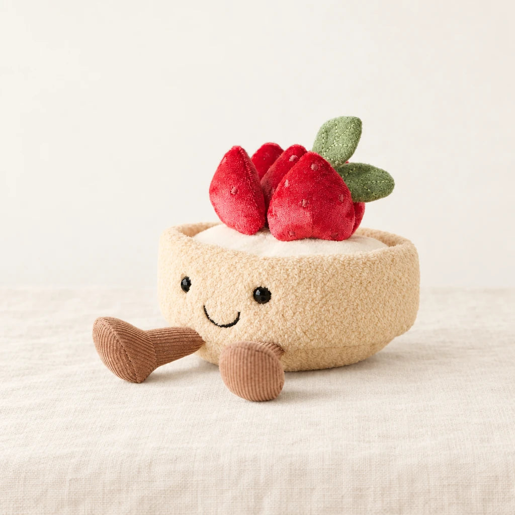 Peluche tarte fraise gourmande kawaii sur fond crème, en studio