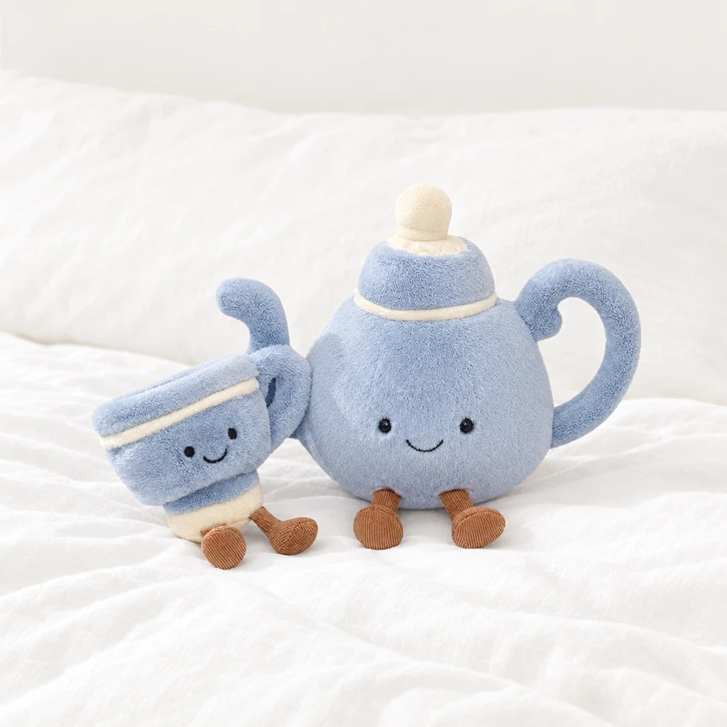 Peluche kawaii tea time tasse et théière posée sur un lit blanc, en pleine lumière