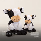 Peluche vache au sourire doux sur fond crème, en studio. 25, 35 ou 50 cm : câlin, jeu ou déco, résiste aux câlins, tous âges