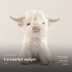 Peluche vache Highland à poils longs blanche sur fond crème, en studio. Un toucher unique : frange fidèle, poils longs, 25 cm