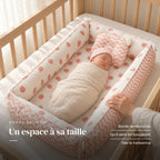 Nouveau-né emmailloté au repos sur le dos, la main d’un parent sur le bord : Réducteur de lit - Cozy